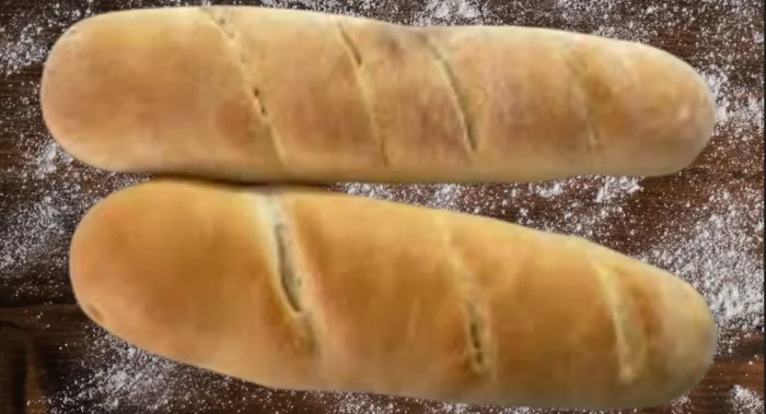 Golden Baked French Bread Loaves on a Floured Wooden Surface,