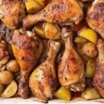 Golden brown roasted chicken and potatoes in a white baking dish.